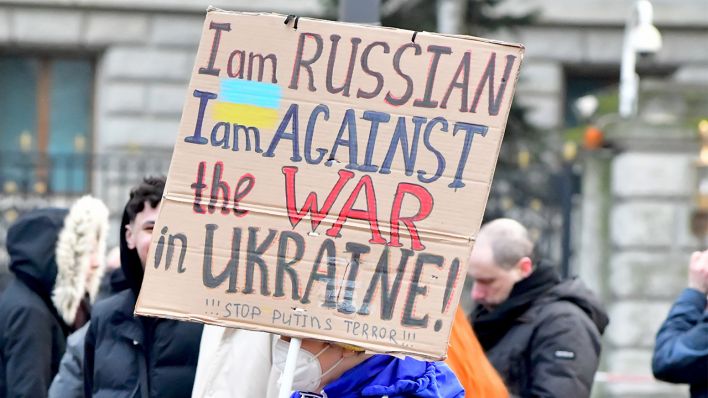Ein Demonstrant vor der russischen Botschaft Berlin bringt am 27.02.2022 mit einem Plakat in der Hand zum Ausdruck, dass er als Russe gegen den Krieg ist. (Quelle: dpa/Matthias Tödt)