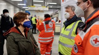 Katja Kipping (Die Linke,l), Berliner Sozialsenatorin, spricht am 03.03.2022 mit DRK-Mitarbeitern, die ukrainischen Flüchtlingen am Hauptbahnhof helfen. (Quelle: dpa/Michael Hanschke)