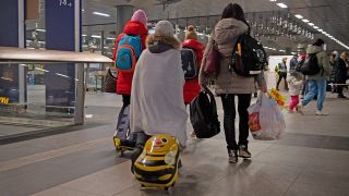 Flüchtlinge aus dem ukrainischen Kriegsgebiet gehen am 08.03.2022 im Berliner Hauptbahnhof zu einer Sammelstelle. (Quelle: dpa/Paul Zinken)