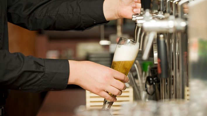Symbolbild: Ein Kellner zapft ein Glas Bier (Bild: imago images/Michaela Begsteiger)
