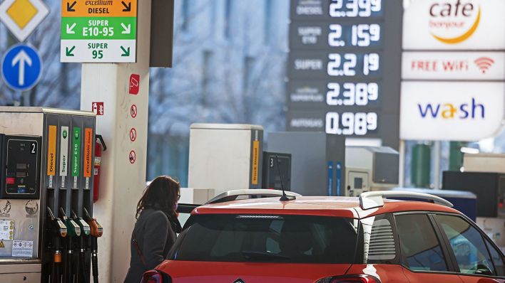 Eine Frau steht mit ihrem Fahrzeug an der Zapfsäule einer Tankstelle (Bild: dpa/Oliver Berg)
