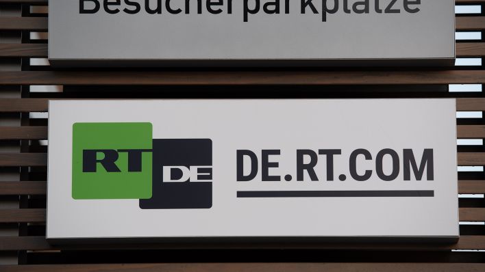 Das Schild des russischen Auslandssenders RT DE hängt vor einem Bürogebäude in Adlershof. (Quelle: dpa/Paul Zinken)