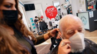 Die Friseurin Dudi Simsek schneidet einem Kunden die Haare im Friseursalon Mac Hair in Wannsee. (Quelle: dpa/Carsten Koall)
