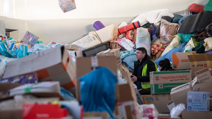 Wojtek, ein freiwilliger Helfer, wirft in einer Schule, die als Lager für Spenden genutzt wird, einen Karton mit Windeln auf einen Haufen. (Quelle: dpa/Sebastian Gollnow)