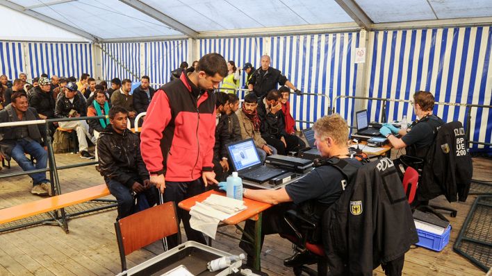 Archivbild: Polizisten erfassen im Herbst 2015 Fingerabdrücke von Geflüchteten mit der Fast-ID-Kontrolle (Bild: dpa/Tobias Hase)