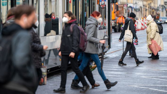 Symbolbild: Fahrgäste mit FFP2-Masken steigen in eine Straßenbahn in der Innenstadt ein. (Quelle: dpa/M. Skolimowska)