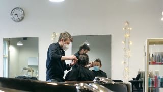 Ein Mann lässt sich von einem Friseur die Haare schneiden (Bild: imago iamges/Noe Sorge)