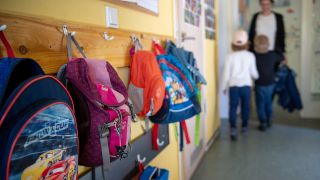 Kinderrucksäcke hängen im Eingangsbereich eines Kindergartens. (Quelle: dpa/Monika Skolimowska)
