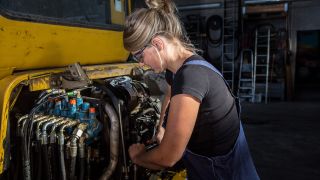 Symbolbild: Eine Frau arbeitet im Beruf als Hydraulik- und Motoren-Fachkraft in einem Betrieb für Reparaturen für Maschinen und Geräte. (Quelle: dpa/K. Schmitt)