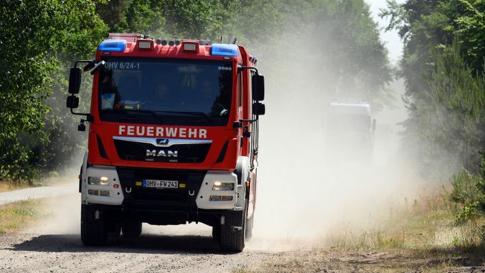 Ein Fahrzeug der Feuerwehr Oberhavel fährt auf dem sandigen Weg durch ein Wald (Quelle: dpa-Zentralbild/Soeren Stache)