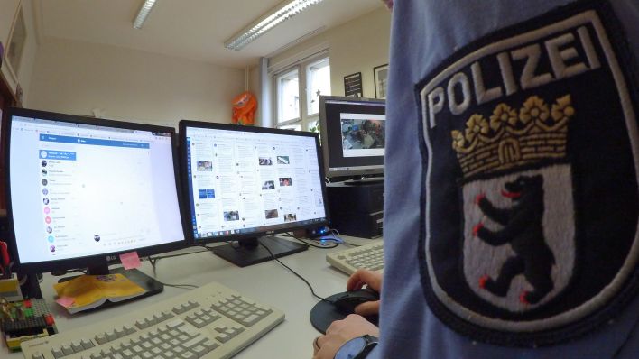 Ein Mitarbeiter der Polizei überprüft Social Media Kanäle. (Quelle: Paul Zinken/dpa)