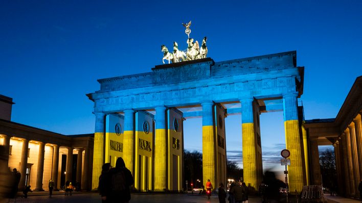 Das Brandenburger Tor wird in den Farben der Ukrainischen Flagge angestrahlt. (Quelle: dpa/Christophe Gateau)