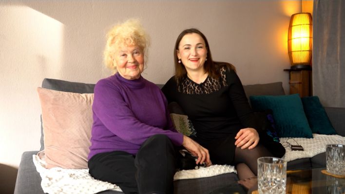 Oma Maria und ihre Enkelin Emiliya sitzen auf einem Sofa in einer Wohnung in Berlin. (Bild: rbb/Fabian Grieger)