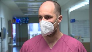 Leitender Oberarzt Thomas Schneider in Arztkittel und mit FFP-2-Maske