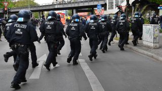 Polizisten laufen am 1. Mai 2021 am Görlitzer Bahnhof in Berlin Kreuzberg über die Straße. (Quelle: dpa/Paul Zinken)