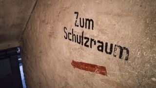 Symbolbild: "Zum Schutzraum" steht an einer Wand im Keller eines Hauses in einem Frankfurter Stadtteil. (Quelle: dpa/Marita Gaul)