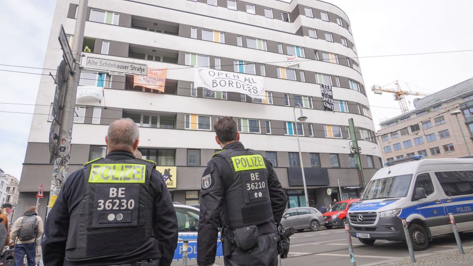 Polizisten stehen vor dem besetzten Wombat City Hostel in Berlin-Mitte (Quelle: DPA/Jörg Carstensen)