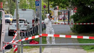 Ein Mitarbeiter der Spurensicherung dokumentiert am 29.04.2022 die Lage am Tatort in der Maximilianstraße, wo eine Frau auf offener Straße getötet worden ist. (Quelle: dpa/Paul Zinken)