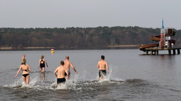 Zahlreiche Badegäste rennen bei der Eröffnung der Freibädersaison im Strandbad Wannsee ins Wasser. (Quelle: dpa/Paul Zinken)