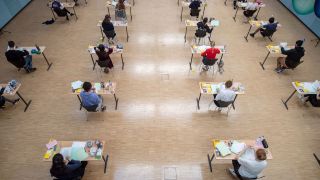 Schülerinnen und Schüler sitzen während einer Abiturprüfung mit dem vorgeschriebenen Abstand zueinander in der Aula. (Quelle: dpa/Marijan Murat)