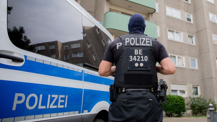 Symbolbild:Ein Polizist steht bei einem Polizeieinsatz in Berlin-Gesundbrunnen. (Quelle: dpa/Christoph Soeder)