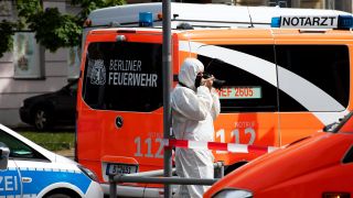 Ein Mitarbeiter der Spurensicherung dokumentiert die Lage am Tatort in der Maximilianstraße, wo eine Frau auf offener Straße getötet worden ist. (Quelle: dpa/Paul Zinken)