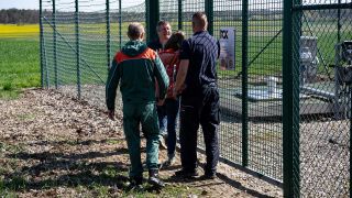 Eine Aktivistin der "Letzten Generation" wird unweit von Breydin (Brandenburg) von Sicherheitskräften am Betreten einer Betriebsanlage der PCK Raffinerie GmbH gehindert. (Quelle: dpa/P. Zinken)