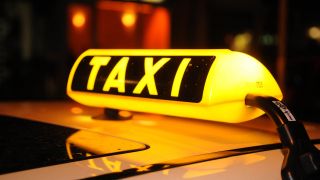 Symbolbild: Ein Taxischild leuchtet bei Nacht auf einem Taxi. (Quelle: dpa/F. Hörhager)