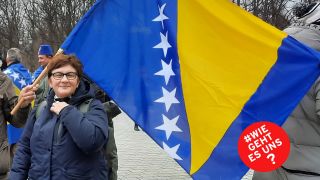 Begzada Alatović steht vor der Flagge von Bosnien und Herzegowina. (rbb/A. Schenten)