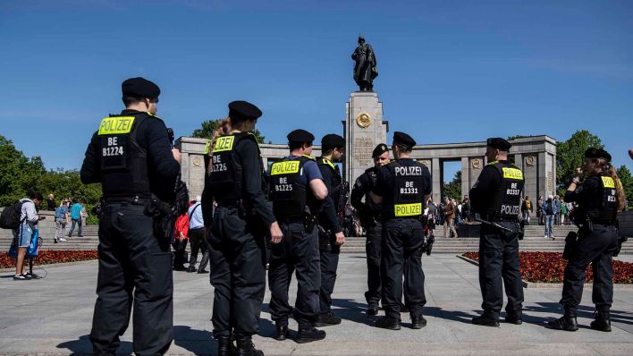 Polizeibeamte beobachten das Geschehen am Ehrenmal an der Straße des 17. Juni. (Quelle: dpa/Paul Zinken)