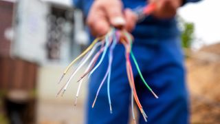 Image symbolique : Un ouvrier montre les fibres épissées d'un câble à fibre optique lors de la connexion d'un câble réseau sur un chantier de construction.  (Source : dpa/A.Franke)