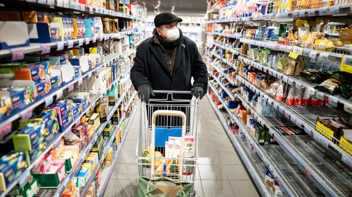 Ein Kunde kauft mit Mundschutz in einem Supermarkt im Berliner Stadtteil Friedenau ein. (Quelle: dpa/Kay Nietfeld)