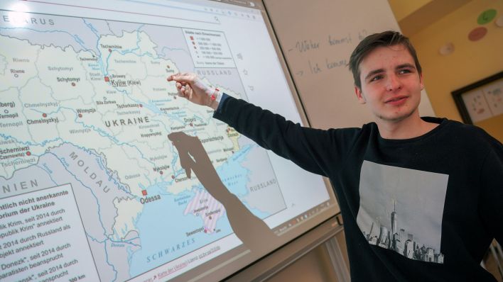 Der Schüler Yehor aus der Willkommensklasse für schutzsuchende SchülerInnen aus der Ukraine zeigt auf einer Karte auf seinen Heimatort Tschernihiw. (Quelle: dpa/Jörg Carstensen)