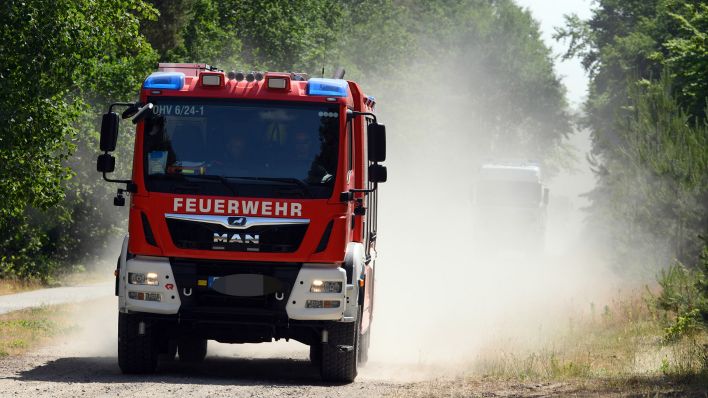 Symbolbild: Ein Fahrzeug der Feuerwehr fährt durch einen trockenes Waldstück in Brandeburg. (Quelle: dpa/S. Stache)
