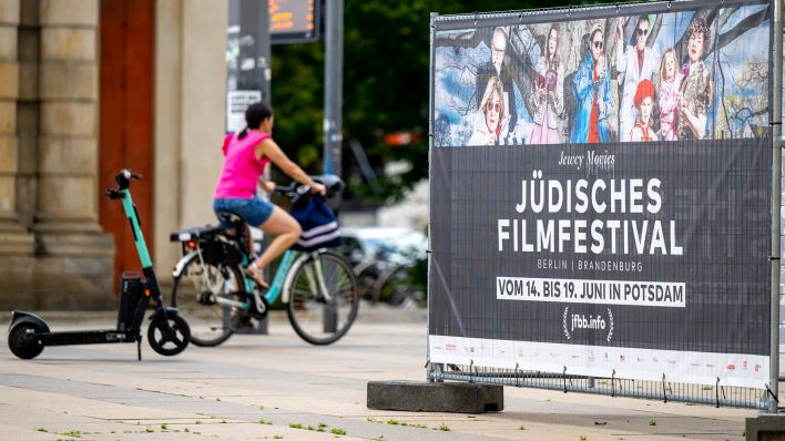 Ein Plakat mit Infos zum Jüdischen Filmfestival steht in der Innenstadt. Das Festival findet vom 14. bis 19. Juni 2022 in Potsdam statt und startet mit dem Film «Eine Frau» der Regisseurin Jeanine Meerapfel. (Quelle: dpa/M. Skolimowska)