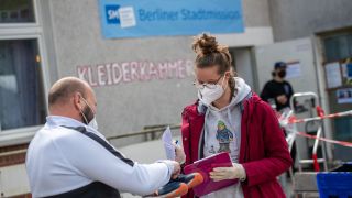 Archvibild: Eine Mitarbeiterin der Berliner Stadtmission verteilt Kleidung. (Quelle: dpa/C. Gateau)