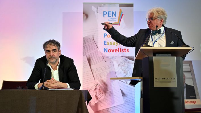 Archivbild: Christoph Nix, PEN- Mitglied, steht neben Deniz Yücel (l), Präsident der Schriftstellervereinigung PEN-Zentrums Deutschland, zu Beginn der Mitgliederversammlung am Rednerpult. (Quelle: dpa/M. Schutt)