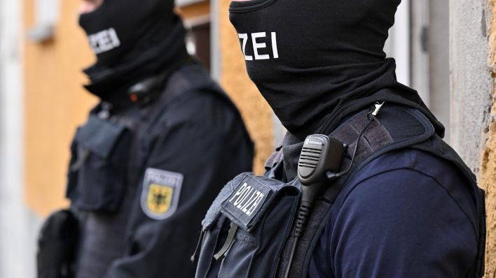 Bundespolizisten stehen vor einem Hauseingang (Bild: dpa/Martin Schutt)
