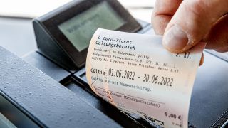 Ein Kunde zieht in einem Bus dein 9-Euro Ticket aus dem Fahrkartendrucker (Quelle: dpa/Markus Scholz)