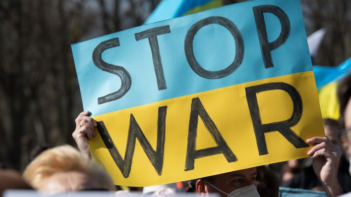 "STOP WAR" steht auf dem Plakat bei einer Protestaktion gegen den russischen Krieg in der Ukraine am Brandenburger Tor. (Quelle: dpa/Paul Zinken)