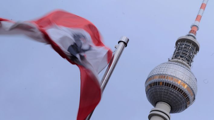 Symbolbild: Die Flagge von Berlin weht zwischen Rotem Rathaus und Fernsehturm im Sturm. (Quelle: dpa/A. Riedl)