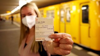 Eine junge Frau hält im U-Bahnhof Potsdamer Platz ein 9-Euro-Monatsticket in der Hand (Quelle: dpa/Kumm)