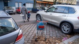 Ein Einkaufswagen blockiert eine freie Parklücke im Berliner Stadtteil Prenzlauer Berg. (Quelle: imago images/T.Seeliger)