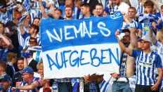 "Niemals Aufgeben" steht auf einem Plakat, das Hertha-Fans im Hinspiel der Relegation hochgehalten haben (imago images/Jan Huebner)