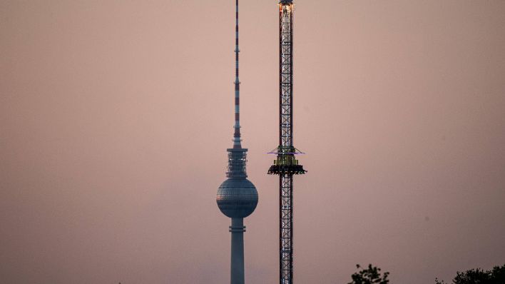 Ein Fahrgeschäft auf dem Neuköllner Maientage Rummel in Berlin. Im Hintergrund ist der Fernsehturm zu sehen. (Quelle: imago images)
