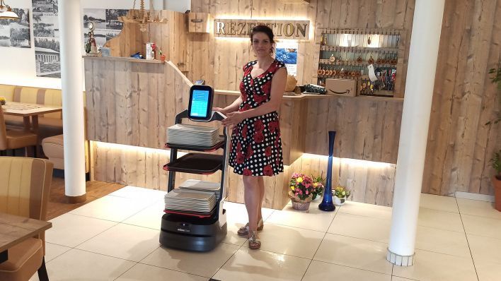 Restaurant- und Hotelchefin Lysann Gutenmorgen mit Service-Roboter Betty. (Foto: rbb/Haase-Wendt)