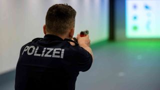 Symbolbild: Ein Polizist der Berliner Polizei steht mit Übungswaffe im Schießstand des Einsatztrainingszentrums der Berliner Polizei. (Foto: Fabian Sommer/dpa)