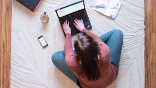 Symbolfoto: Eine Frau sitzt im Homeoffice auf einem Teppich und arbeitet an einem Laptop (gestellte Szene) (dpa / Sebastian Kahnert).