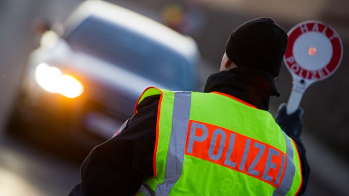 Symbolbild: Ein Polizist stoppt am frühen Morgen am 05.03.2013 ein Auto in Brandenburg. (Quelle: dpa/Patrick Pleul)