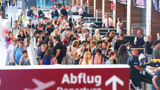 Zahlreiche Passagiere stehen in einer Schlange bei der Sicherheitskontrolle am Flughafen Berlin-Brandenburg. (Quelle: dpa/J.Carstensen)